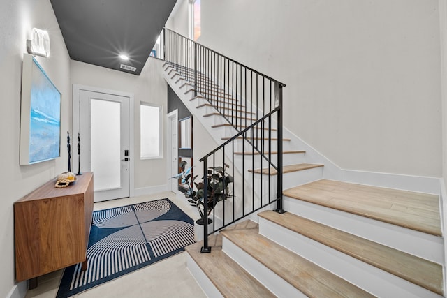 foyer entrance with baseboards and stairway