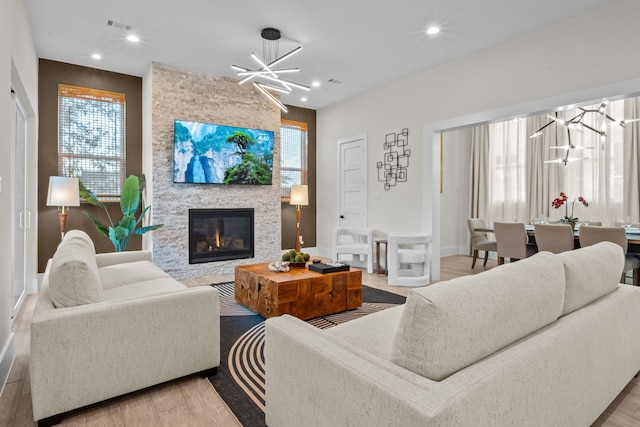 living room with a chandelier, recessed lighting, wood finished floors, and a healthy amount of sunlight