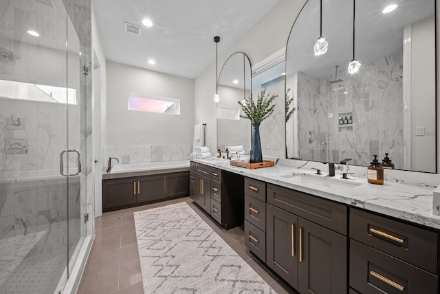 bathroom featuring a marble finish shower, double vanity, visible vents, a sink, and a bath