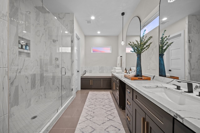 bathroom featuring double vanity, tile patterned flooring, a shower stall, and a sink