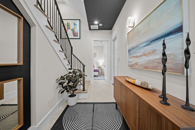 hallway featuring visible vents, baseboards, and stairs