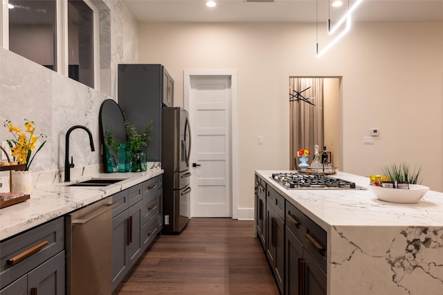 915 Thompson St, Houston, TX 77007 - kitchen with a center island, dark wood-style flooring, appliances with stainless steel finishes, a sink, and light stone countertops