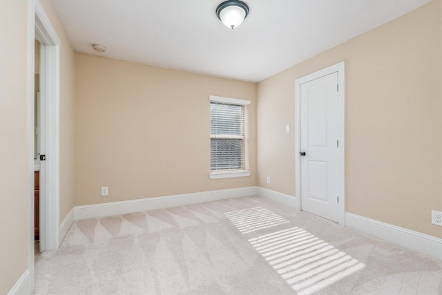 carpeted spare room with baseboards