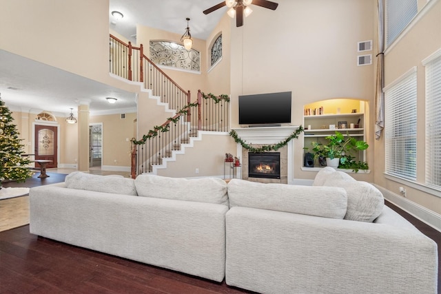 living area featuring a fireplace, visible vents, stairway, dark wood-type flooring, and baseboards