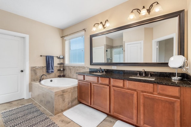 bathroom with double vanity, a garden tub, a sink, and a stall shower