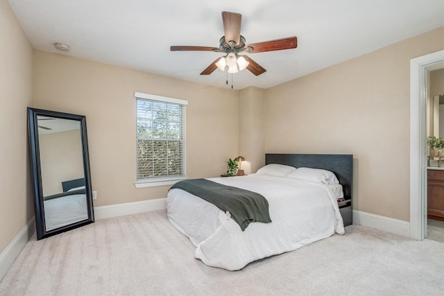 carpeted bedroom featuring a ceiling fan, connected bathroom, and baseboards