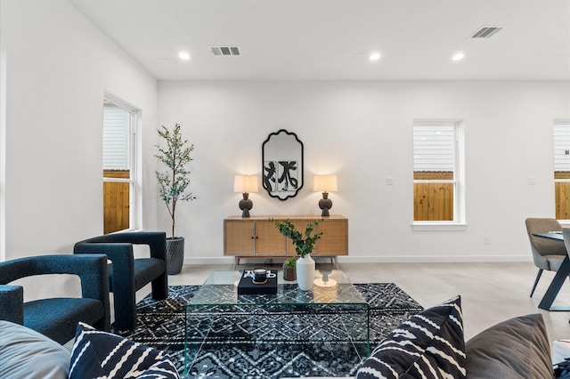 living area with baseboards, visible vents, and recessed lighting