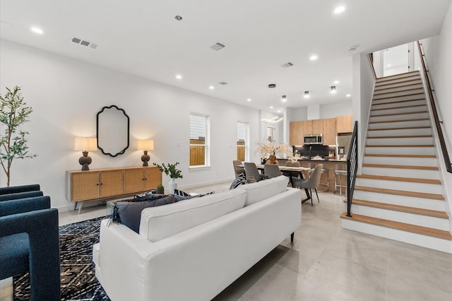 living area featuring stairway, visible vents, and recessed lighting