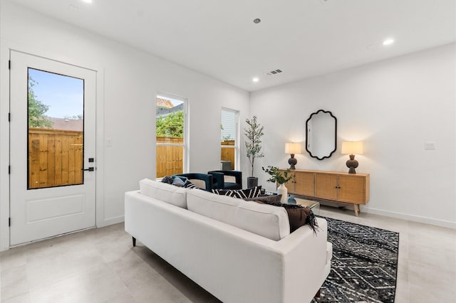 living area with baseboards, plenty of natural light, and recessed lighting