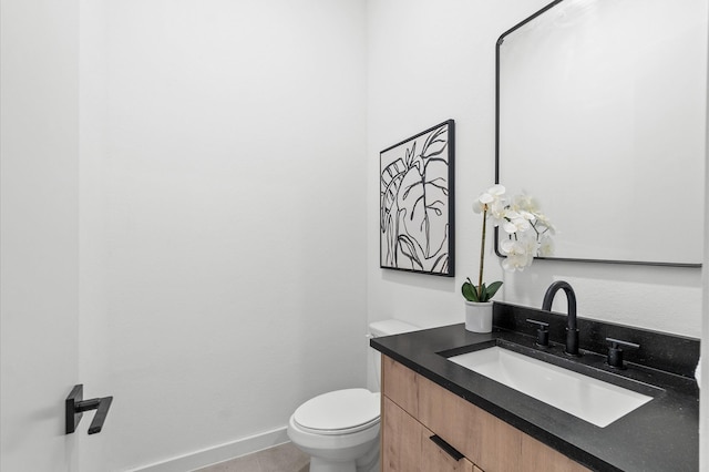 bathroom with toilet, tile patterned flooring, baseboards, and vanity