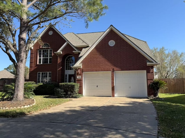 traditional-style home featuring a garage, brick siding, concrete driveway, and fence