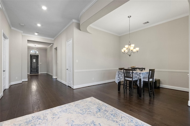 dining area with a chandelier, wood finished floors, visible vents, and baseboards