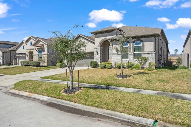 view of front of property featuring a garage, stone siding, driveway, stucco siding, and a front yard