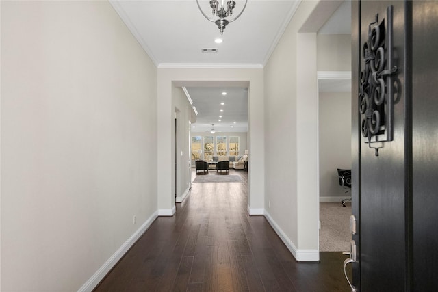 hall with dark wood finished floors, recessed lighting, visible vents, ornamental molding, and baseboards