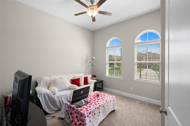 living area with carpet floors, ceiling fan, and baseboards