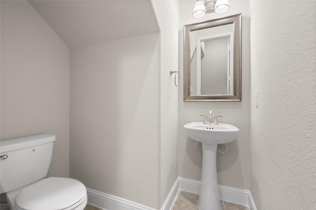 bathroom with toilet and baseboards