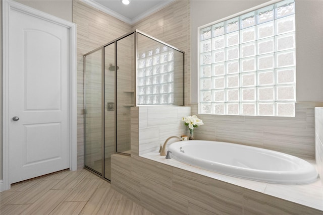 full bath with a garden tub, crown molding, and a shower stall