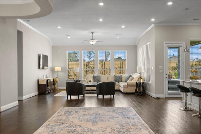 living area featuring baseboards, ornamental molding, and dark wood finished floors