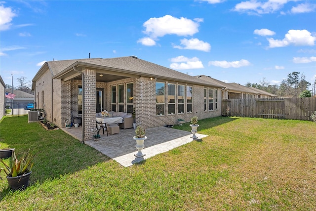 back of house featuring a patio area, brick siding, a fenced backyard, and a lawn