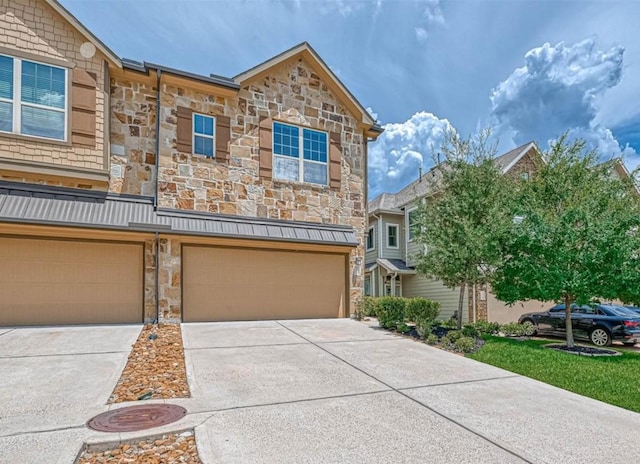 multi unit property featuring stone siding, concrete driveway, and an attached garage