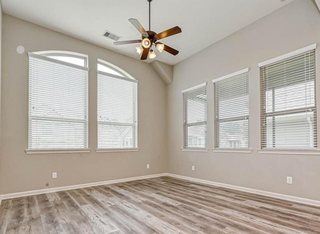 unfurnished room with visible vents, ceiling fan, light wood-style flooring, and baseboards