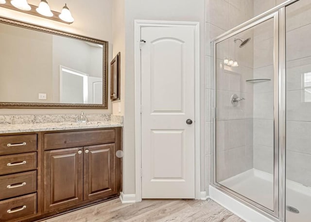 full bath featuring a shower stall, vanity, and wood finished floors