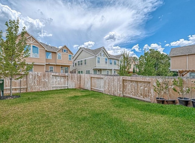 view of yard with a fenced backyard and a residential view