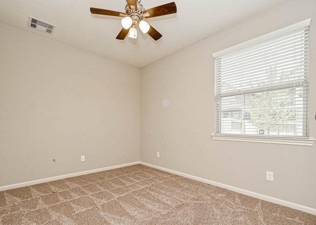 carpeted spare room with a ceiling fan, visible vents, and baseboards