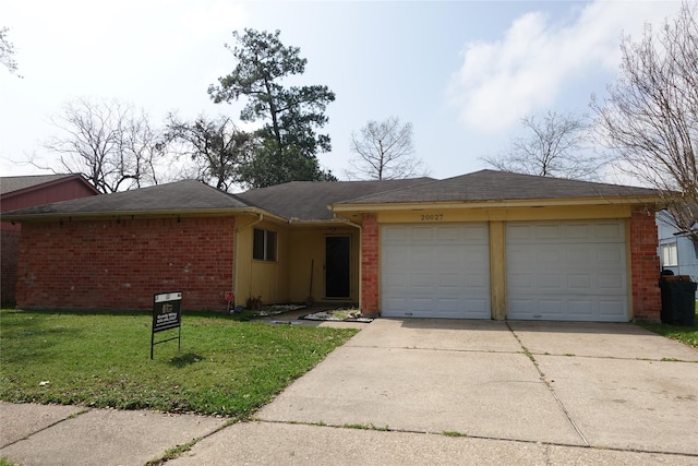 ranch-style home with brick siding, an attached garage, concrete driveway, and a front yard