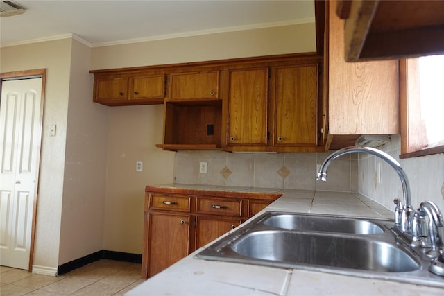 kitchen featuring ornamental molding, visible vents, brown cabinets, and a sink