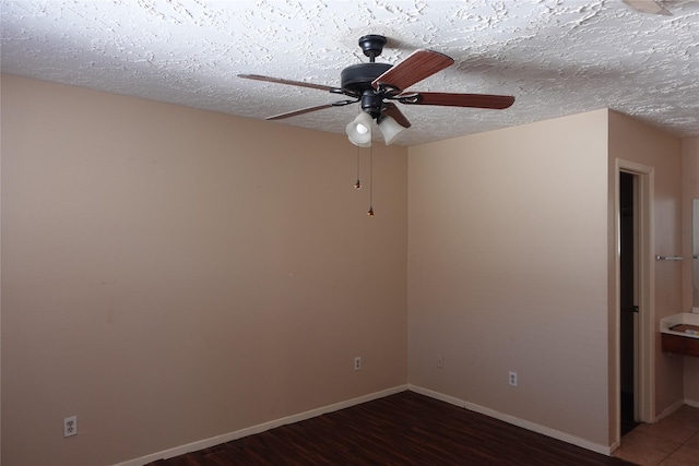 spare room featuring ceiling fan, baseboards, a textured ceiling, and wood finished floors