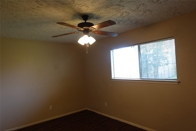 unfurnished room with dark wood-type flooring, baseboards, and a textured ceiling