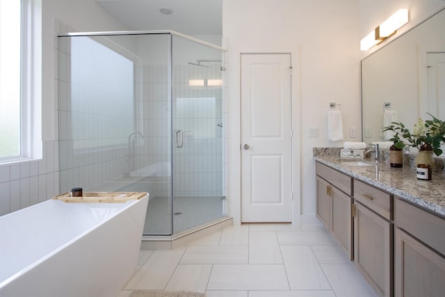 full bathroom with tile patterned flooring, a shower stall, a freestanding bath, and vanity