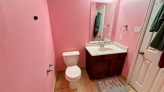 bathroom with tile patterned floors, vanity, toilet, and baseboards