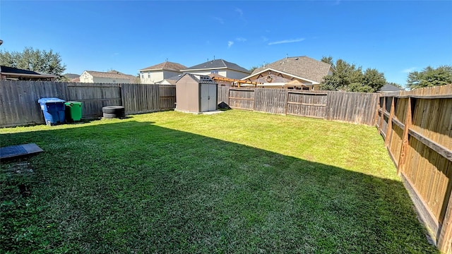 view of yard featuring an outbuilding, a fenced backyard, and a storage shed