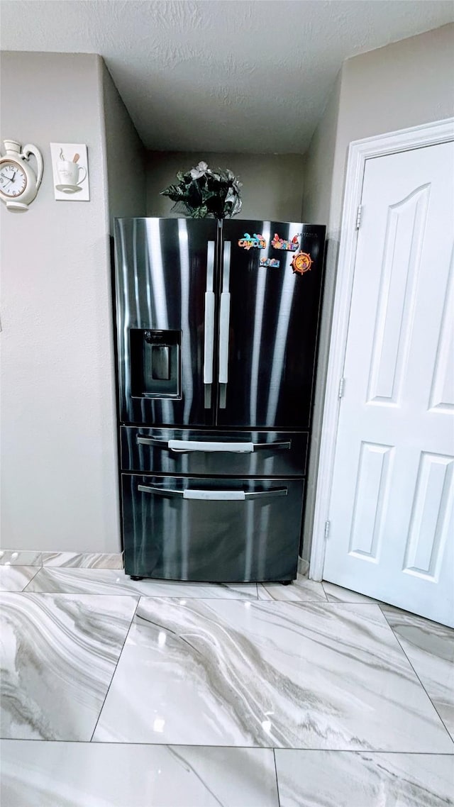 interior details with a textured ceiling and black fridge