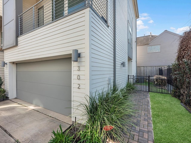 view of property exterior featuring a garage, a yard, and fence