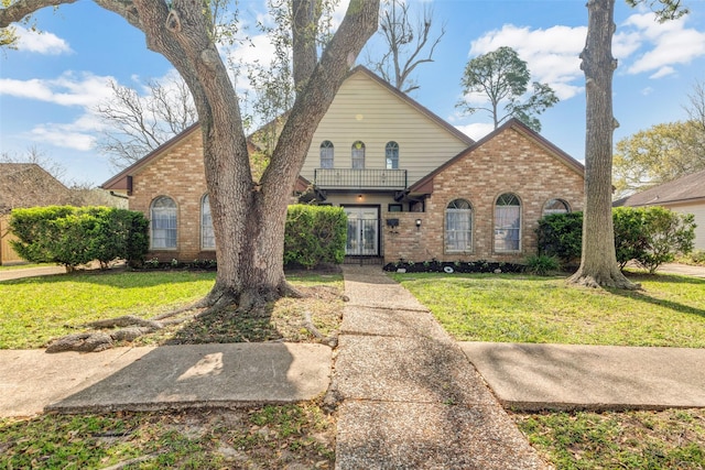 traditional-style home featuring brick siding and a front yard