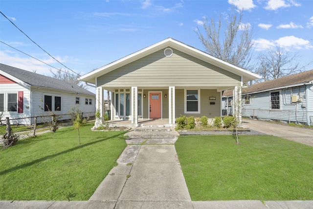 view of front of property with covered porch, fence, and a front lawn