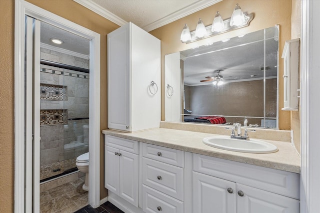 ensuite bathroom with toilet, ornamental molding, a stall shower, a textured ceiling, and vanity