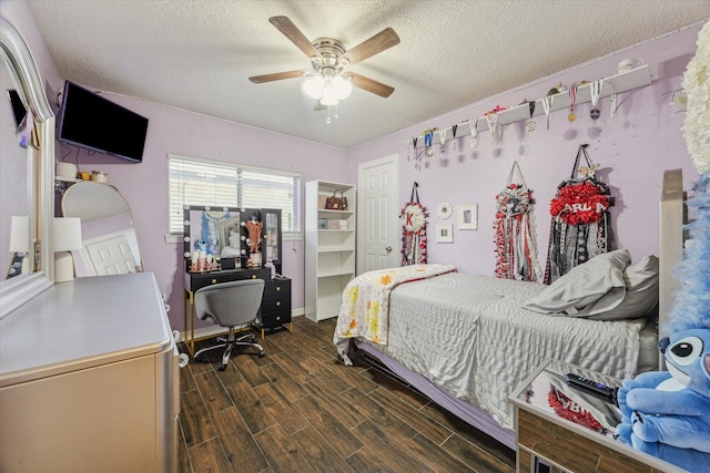 bedroom featuring a textured ceiling, ceiling fan, baseboards, and wood tiled floor