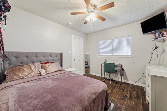 bedroom with wood tiled floor, baseboards, ceiling fan, and a textured ceiling