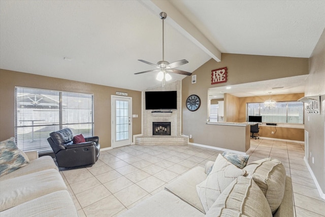 living room featuring lofted ceiling with beams, a brick fireplace, ceiling fan, and light tile patterned flooring