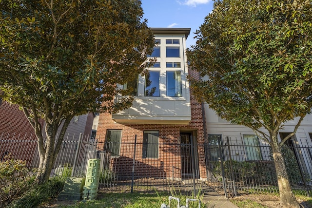 view of front of property featuring a fenced front yard and brick siding