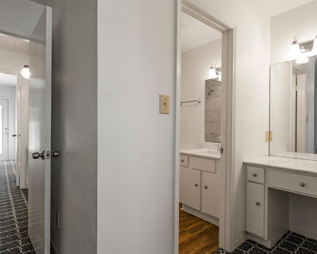 bathroom with a shower, wood finished floors, and vanity