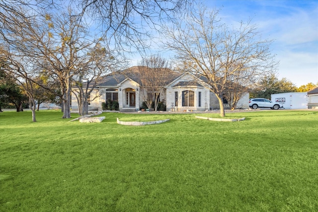 view of front facade featuring stone siding and a front lawn