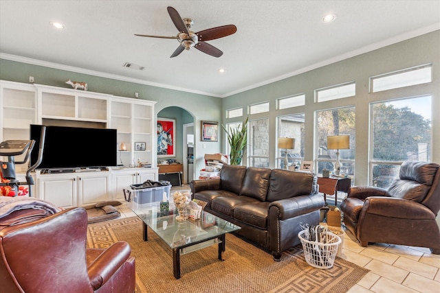 living area featuring arched walkways, crown molding, light tile patterned floors, visible vents, and a ceiling fan