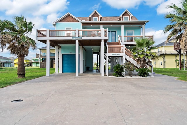 coastal inspired home with driveway, covered porch, a front lawn, and a carport