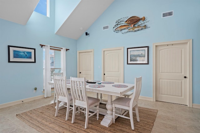 dining room featuring high vaulted ceiling, visible vents, baseboards, and light tile patterned floors