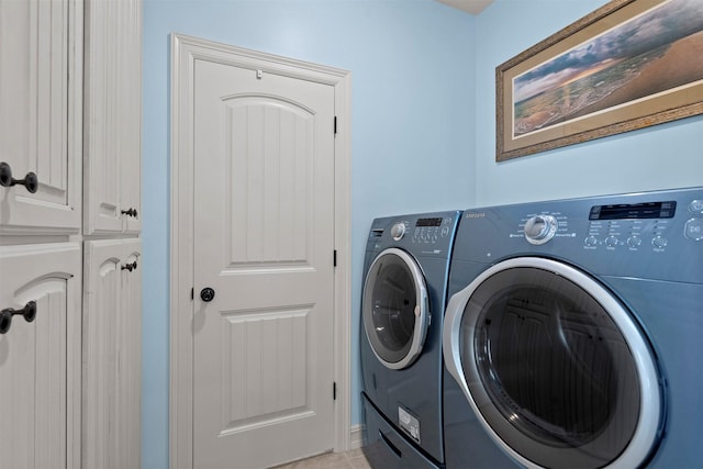 laundry room featuring washing machine and clothes dryer and cabinet space